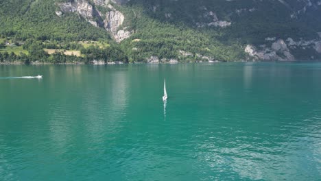 Aerial-arc-shot-of-motor-boat-and-yacht-sailing-in-tranquil-Switzerland-lake