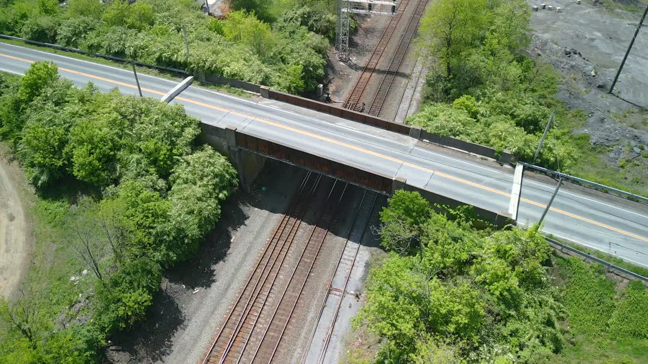 Aerial drone view of a bridge going over a railroad.