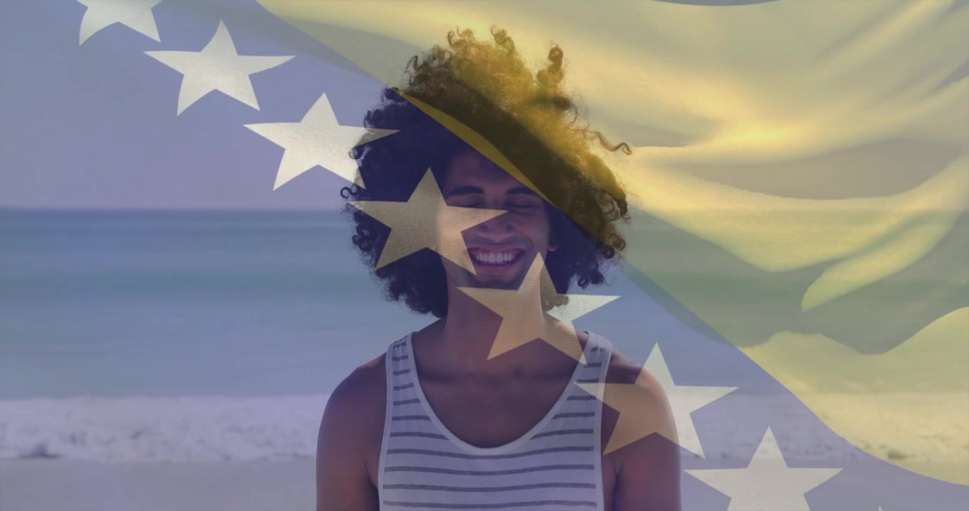 Ein Mann steht am Ufer, eine transparente Flagge mit Sternen weht über sein Gesicht und löst ein Lächeln für Marketingzwecke aus.