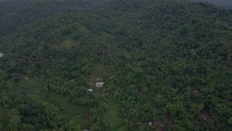 Aerial-view-of-rural-landscape-of-Indonesian-with-view-of-endless-jungle-on-the-hills-in-foggy-morning