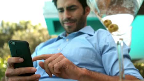 hombre de negocios usando su teléfono inteligente en silla de sol