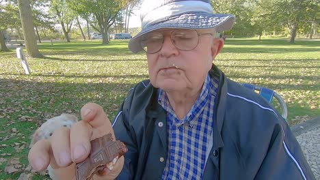 older man enjoying eating a messy smore with chocolate on his face