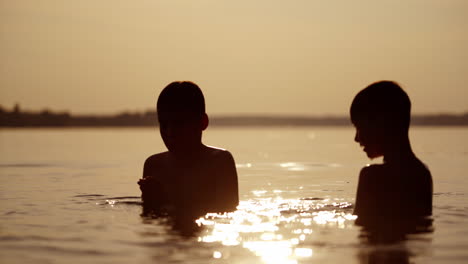 children playing in a river. silhouette of children playing in water