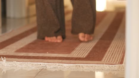 person walking on a brown prayer rug