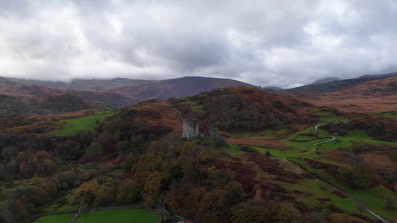 Aerial drone video of Dolwyddelan Castle in Snowdonia National Park, showing the medieval hilltop ruins and the dramatic Welsh highland landscape surrounding this historic stronghold