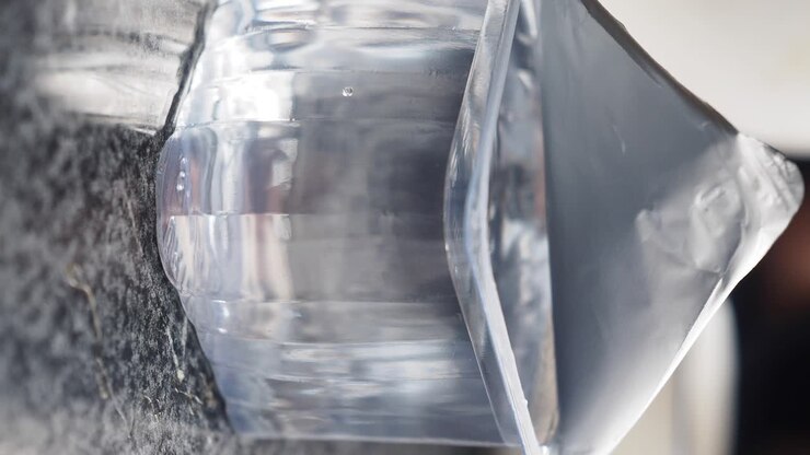 Primo piano di una bottiglia d'acqua di plastica trasparente