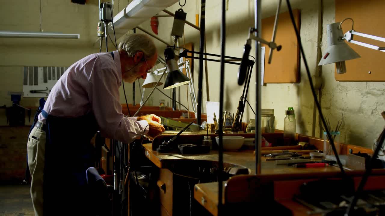 ювелир, работающий за столом в мастерской 4k