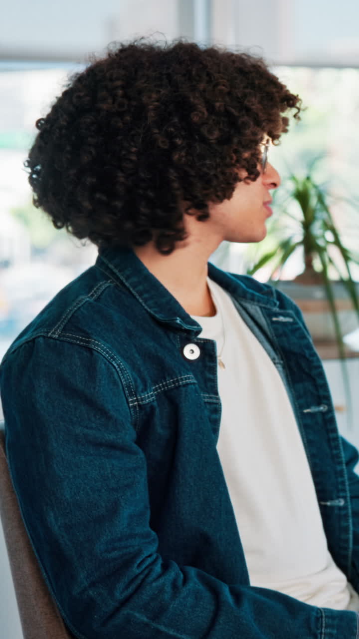Uomo con i capelli ricci che indossa una giacca di jeans