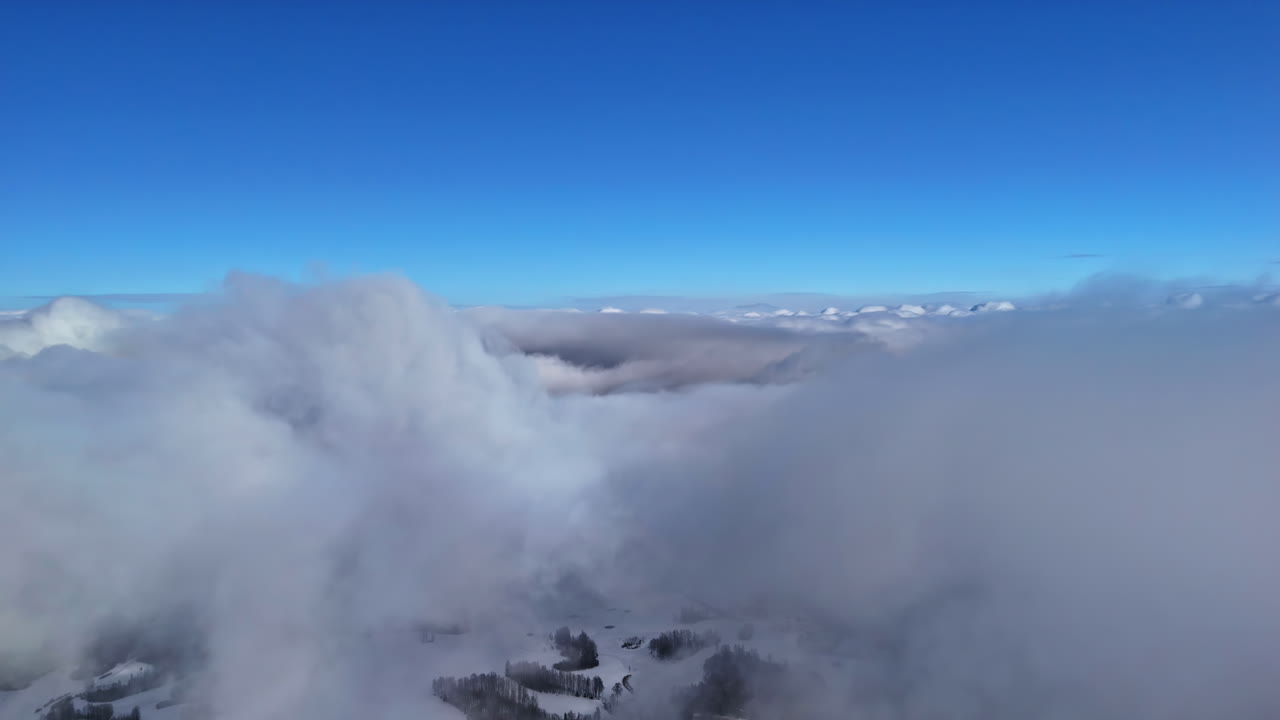 A white cloud cover under a blue sky reveals a winter landscape on Earth