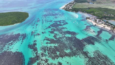 aerial view of a tropical coastline with turquoise waters, coral reefs, and a beach resort