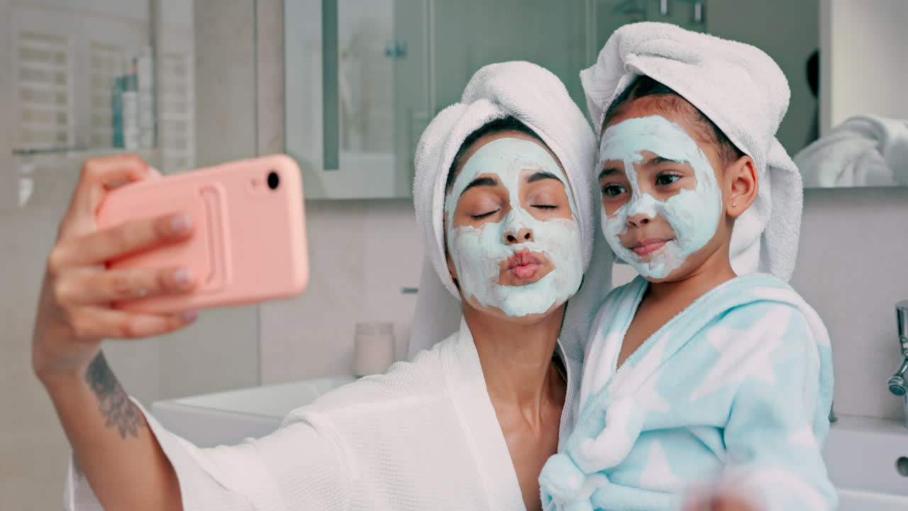 Madre e figlia che si fanno un selfie con maschere per il viso