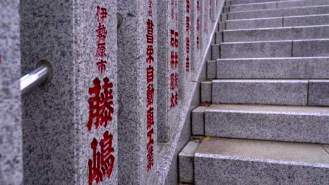 Close-up-of-walk-up-stone-steps-with-Japanese-characters-on-stone-pillars