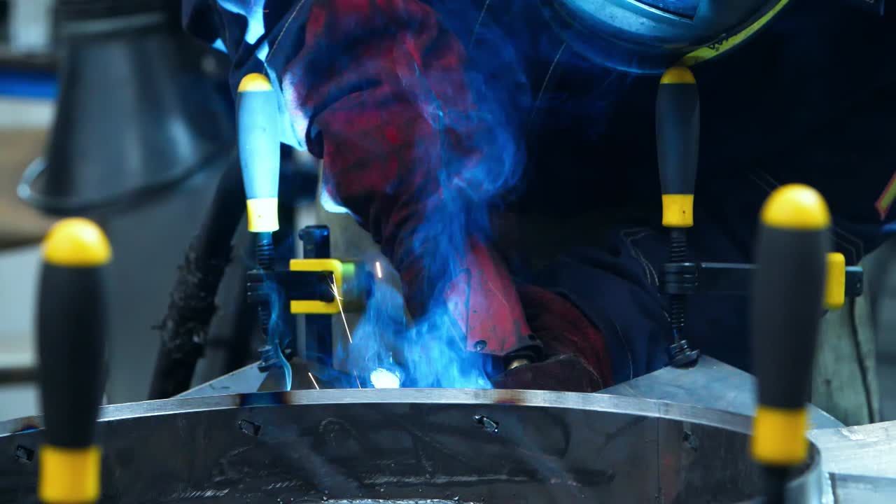 Welding torch nozzle in action close up. Man making weld in workshop