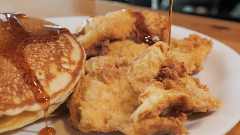 warm maple syrup drizzles over short stack pancakes and fried chicken -- 4k