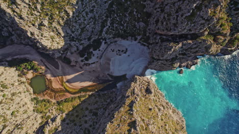 Overhead-View-Of-Sa-Calobra-Cove-Beach-At-The-Rivermouth-Of-Torrent-de-Pareis-In-Sierra-de-Tramuntana,-Mallorca,-Spain