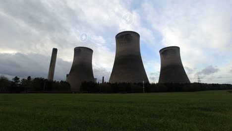 símbolos de energía que parpadean sobre múltiples chimeneas de la estación de energía lapso de tiempo con nubes moviéndose rápidamente por encima