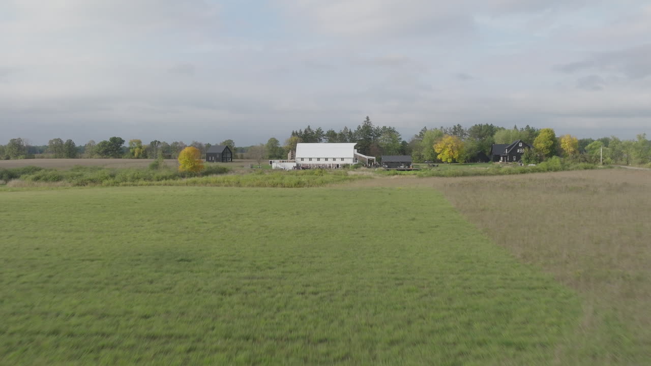 granero blanco en un campo de granja rural expansivo durante el día, aérea