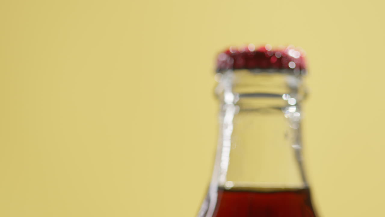 Pull Focus Close Up Shot Of Condensation Droplets On Neck Of Revolving Bottle Of Cold Beer Or Soft Drink With Metal Cap