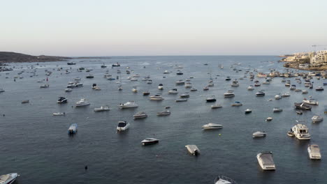 Toma-Aérea-Sobrevolando-Cientos-De-Yates-Anclados-En-Una-Bahía-Marina,-Malta