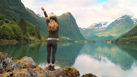 mujer disfrutando del paisaje de un fiordo noruego