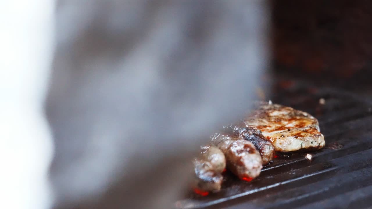 Grilling sausages and chicken on a barbecue with vibrant vegetables in the background