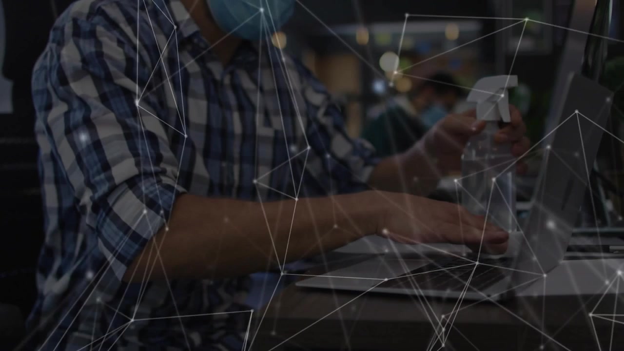 Man grabbing wipe, sprayer, wiping laptop trackpad to clean for IT use, overlay showing progress