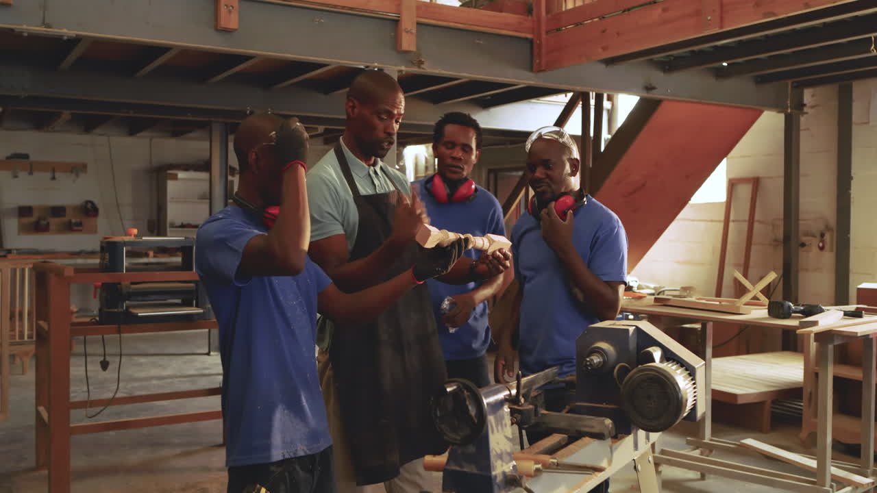 African American instructor rotating spindle as male apprentices measuring spiral with tape measure
