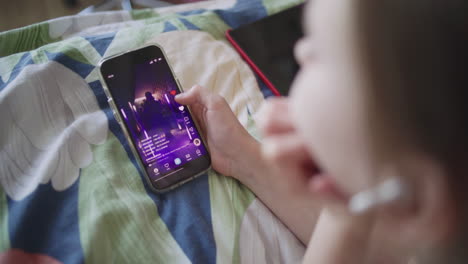 person watching a video on their smartphone in bed