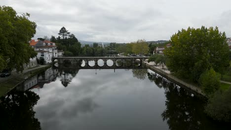 High-drone-dolly-push-in-to-roman-bridge-of-Aquae-Flaviae,-Chaves-Vila-Real-Portugal-on-cloudy-day