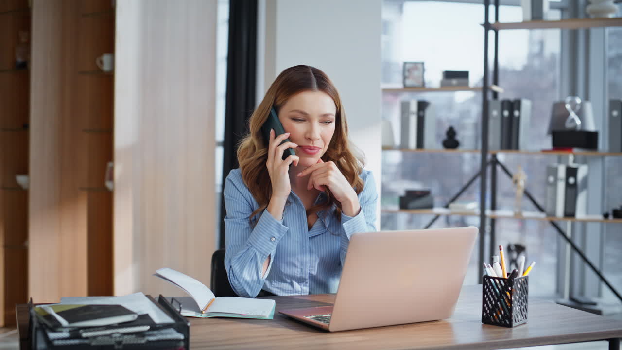 Primo piano di donna d'affari che parla al cellulare in ufficio. Manager sorridente in consulenza.