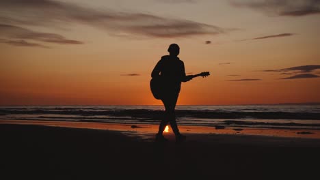 man running with guitar in back sand beach at sunset-10