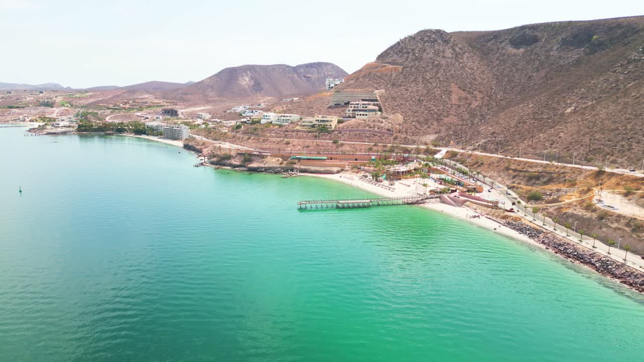 Playa coromuel beach in la paz, showcasing clear turquoise waters and hills, aerial view
