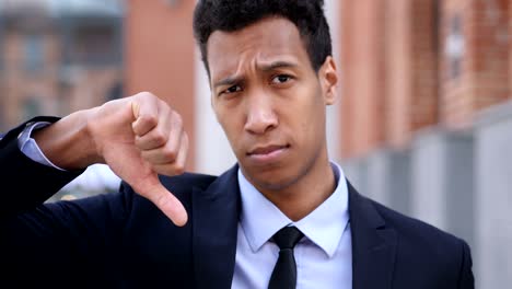 thumbs up by african businessman sitting on bench