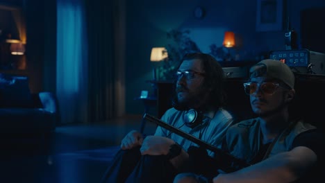 two men relaxing in a dimly lit room at night