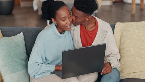 Black-couple,-laptop-and-home-sharing-kiss