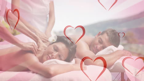 animation of hearts falling over caucasian couple in spa during massage