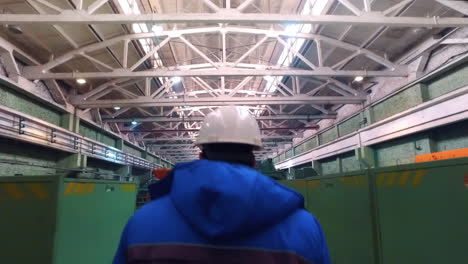 worker walking in workshop of steel factory. engineer walking at metal factory