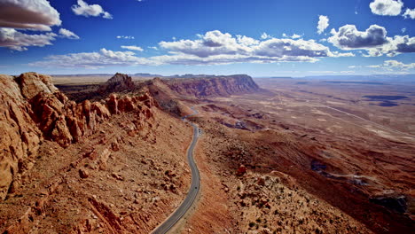 a drone captures the wild mountain pass etched through red rock near page, arizona.