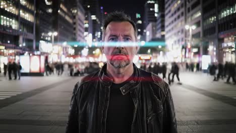 a man in a leather jacket stands still amid a busy city street at night, illuminated by bright urban lights. people move quickly around him, creating a vibrant atmosphere.