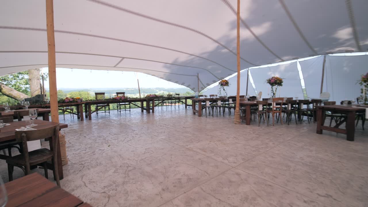elegante ambiente de recepción de bodas boho chic bajo una gran carpa, sillas y mesas