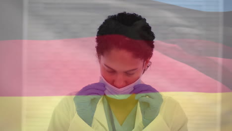 animation of flag of germany over biracial female doctor with face mask