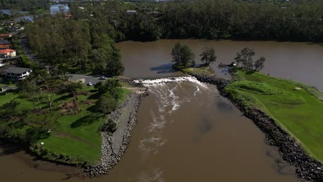 Oxenford,-Gold-Coast,-4-De-Enero-De-2024:-Toma-Aérea-Ascendente-Del-Río-Coomera-Y-La-Calzada-Con-El-Retroceso-De-Las-Aguas-De-Las-Tormentas-De-Enero