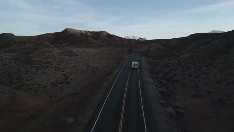 A-lone-camper-truck-meanders-along-the-road,-navigating-the-isolated-scenery-of-Utah,-USA,-the-spirit-of-van-life---a-lifestyle-grounded-in-freedom,-adventure,-endless-exploration-on-the-open-road