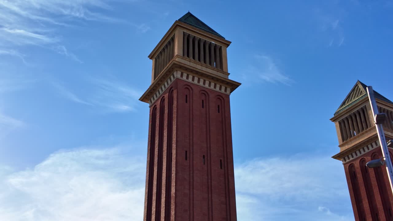 Vista en ángulo bajo de las Torres Venecianas en la entrada del área de exposiciones de Montjuïc en Barcelona, España. Descenso de cámara