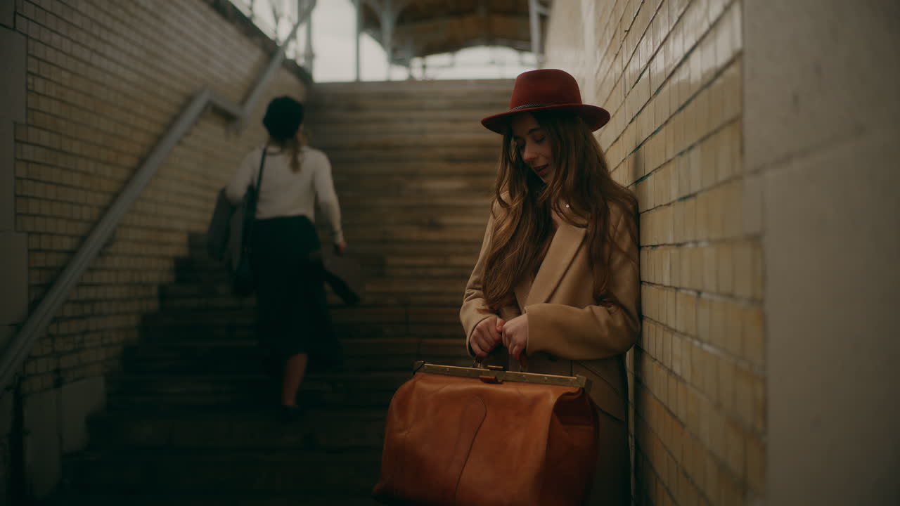 улыбающаяся женщина, опирающаяся на стену.