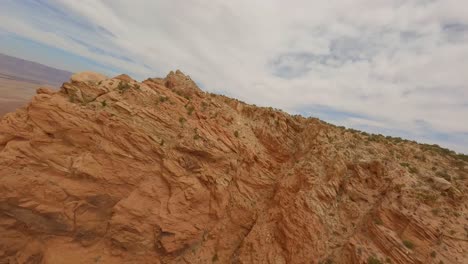 aerial fpv flying through red sandstone rock cliff formations in arizona