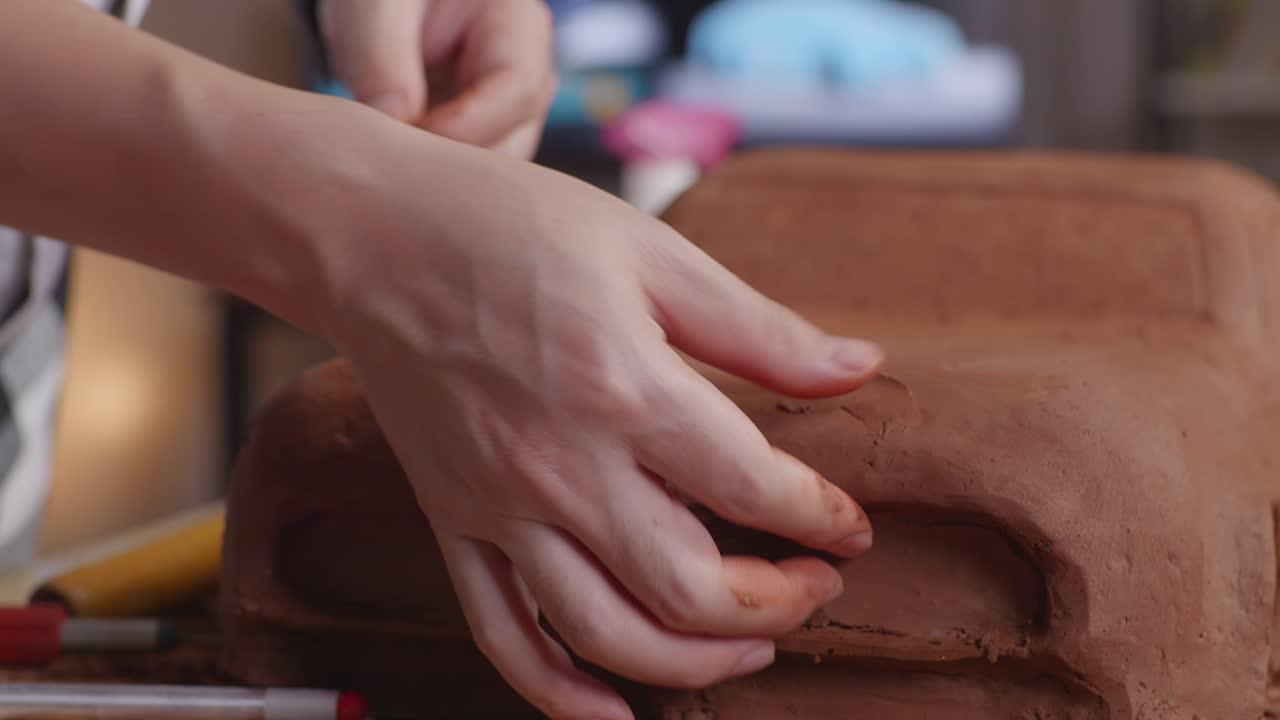 자동차 디자이너의 손은 표면을 매끄럽게하고 스튜디오에서 자동차 점토 조각에서 세부 사항을 만니다.