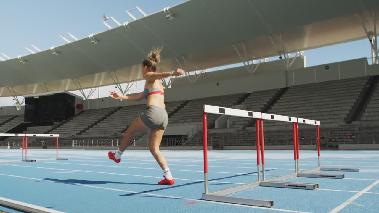 atleta caucásico haciendo obstáculos en el estadio