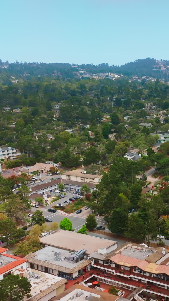 Cozy lovely city of Carmel-by-the-sea in California. Green city panorama with mountains at backdrop. Top view. Vertical video