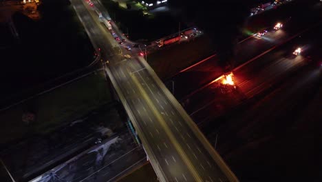 real-life nighttime aerial footage of a vehicle fire on the highway in pickering, canada. first responders manage traffic and work to extinguish the blaze. a dramatic emergency scene unfolds